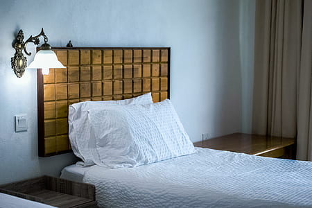White Bedding Cover Beside Brown Wooden Side Table thumbnail