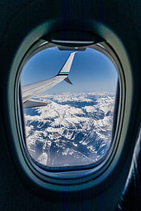 white airplane near snowy mountain thumbnail