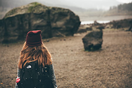 woman standing near gray rock formations thumbnail