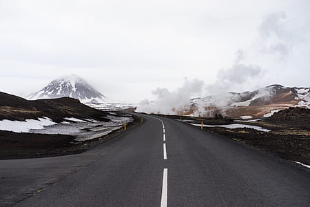gray concrete road near mountain thumbnail