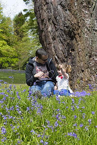man beside girl sitting beside tree thumbnail