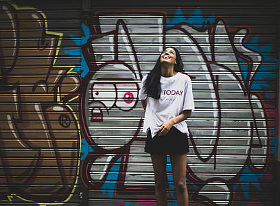 woman looking up while standing against wall thumbnail