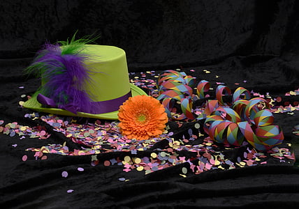 green hat beside orange petaled flower thumbnail