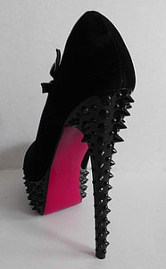 unpaired studded black Christian Louboutin stiletto on white surface thumbnail