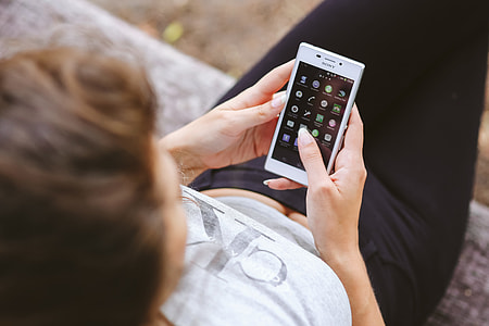 Young woman holding the white mobile phone thumbnail