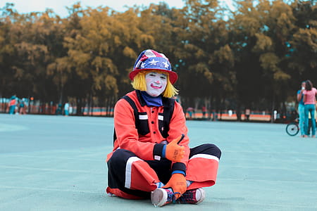 Low-angle of Clown Sitting on Ground thumbnail