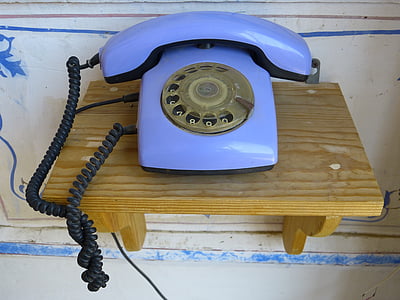 blue rotary phone on brown wooden shelf thumbnail