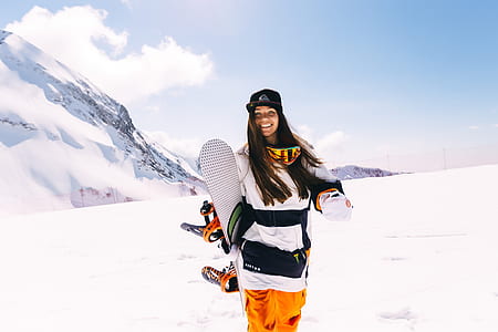 woman holding snowboards during winter season thumbnail