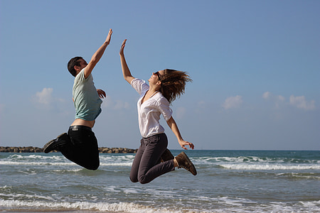 man and woman jumping photo in the sea thumbnail