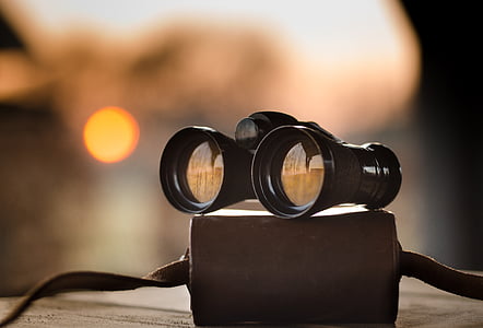 black binoculars on beige surface thumbnail
