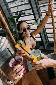 close-up photography of three person holding filled disposable cups thumbnail