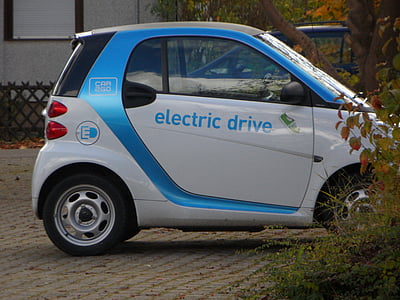 white smart car parked beside bushes thumbnail