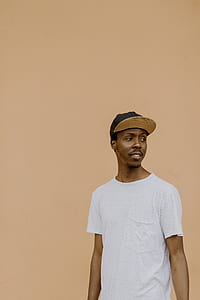 man wearing white crew neck t-shirt and brown fitted cap thumbnail
