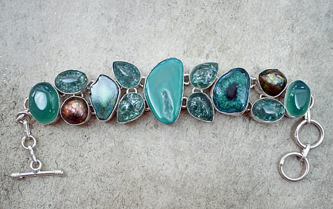 silver-colored with blue gemstone bracelet on gray textile thumbnail