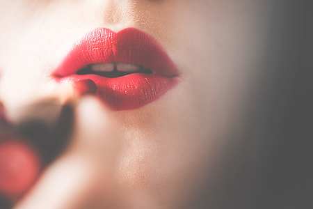 Young & Pretty Woman Applying Red Lipstick on Lips thumbnail