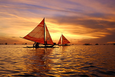 two brown and red sailing boats during sunset thumbnail