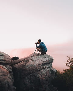 man doing photography on large brown rock thumbnail