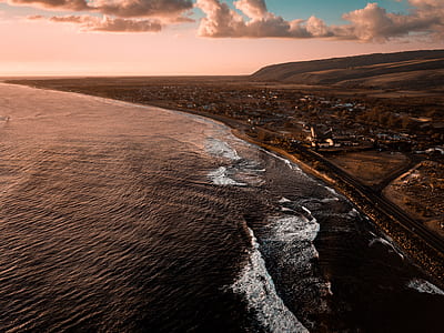 aerial view of roadway beside body of water thumbnail