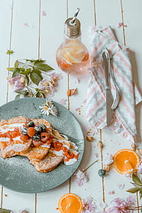 flat lay photo of cooked food on grey plate with cruet and silver fork and knife thumbnail