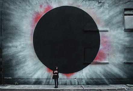 woman standing near wall with solar eclipse painting thumbnail