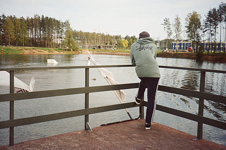 Photo of a Person Standing in Front of a Lake thumbnail