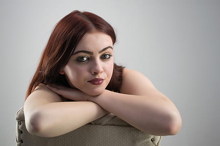 woman sitting on gray chair while taking a photo thumbnail
