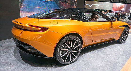 man inside orange and black sports coupe thumbnail