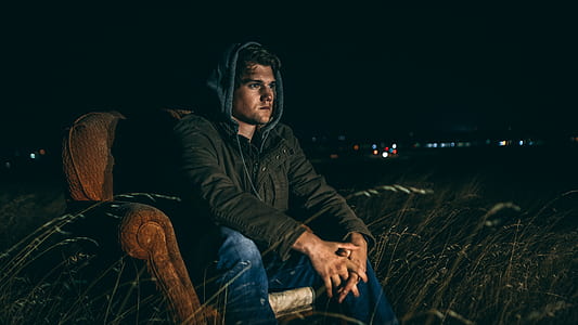 man sitting on brown fabric sofa chair thumbnail