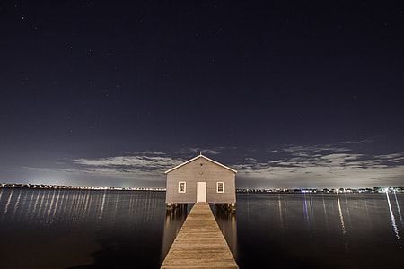 gray wooden house beside wooden dock in between body of water thumbnail