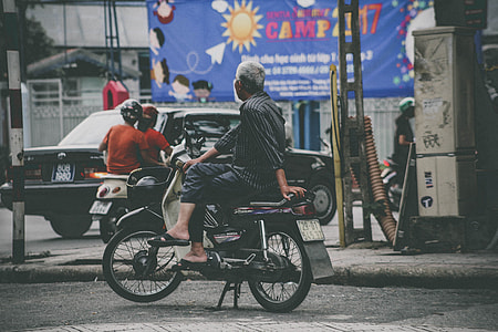 man sitting on motorcycle on street thumbnail