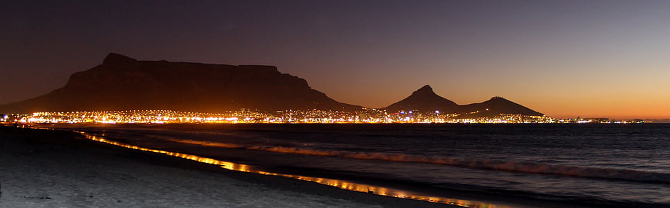 seashore and view of lighted mountain thumbnail