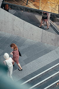 two women walking near alley during daytime thumbnail