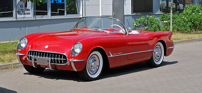 classic red convertible coupe parked near house thumbnail