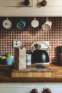 black and beige whistle kettle near on chopping board thumbnail