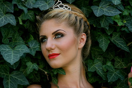 close-up of a woman's face against green leaf plants thumbnail