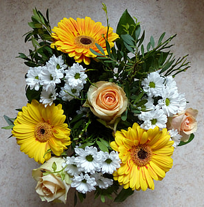 close-up photo of white chrysanthemum, yellow gerbera daisies, pink roses, and green leaves centerpiece thumbnail