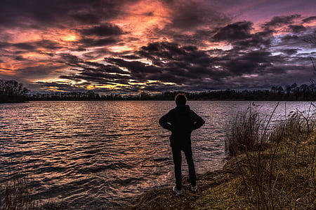 person standing near seashore at sunset thumbnail