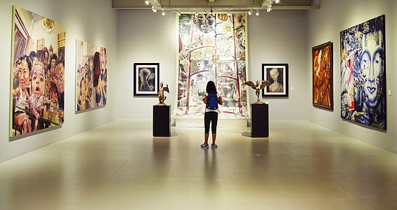 standing woman wearing backpack in painting museum thumbnail