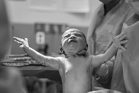 grayscale photography of doctor holding new born baby thumbnail