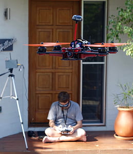 man sitting on floor beside tripod thumbnail
