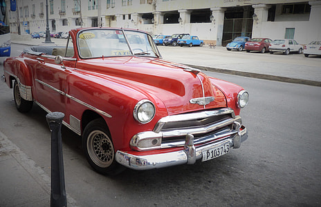 classic red convertible coupe parked on roadside during daytime thumbnail