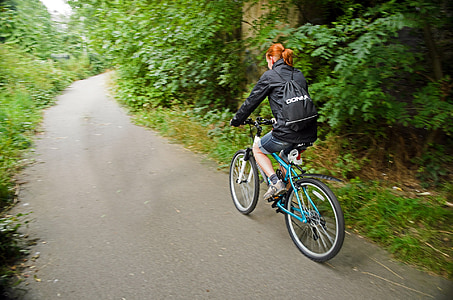 main in black jacket riding in blue mountain bike thumbnail