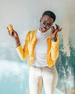 smiling woman holding her sunglasses and coned ice cream thumbnail
