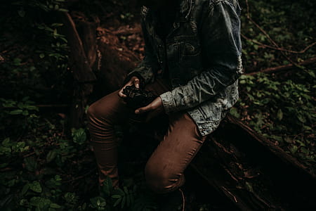 person wearing jacket and brown pants sitting on brown board thumbnail