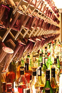 drinking glasses on rack and wine bottles on table thumbnail