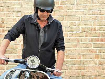 man riding black motorcycle wearing helmet thumbnail