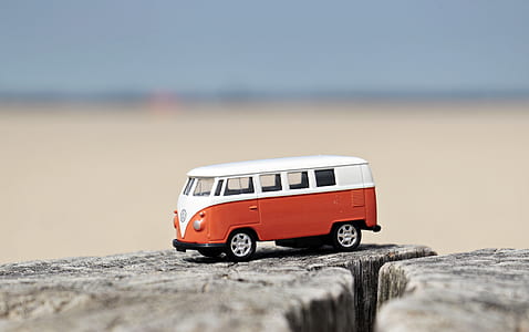 shallow focus photography of white and red Volkswagen Samba die-cast toy car thumbnail