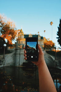person holding iPhone taking photo of gray bridge thumbnail
