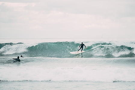 man surfing on sea waves during daytime thumbnail