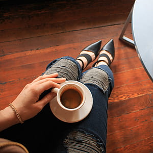 woman sitting while holding ceramic mug thumbnail